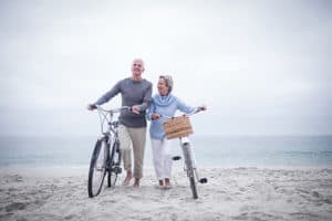 Senior couple on the beach with bikes