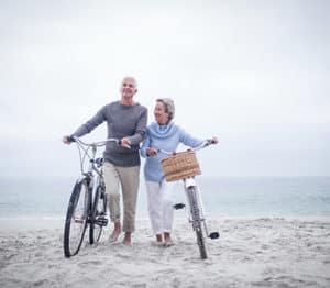 Senior couple on the beach with bikes