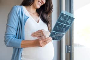 Pregnant woman looking at ultrasound images