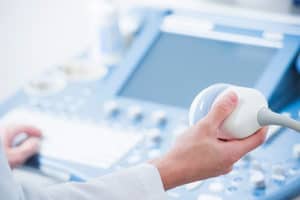 Close up of technician's hands operating a vascular ultrasound