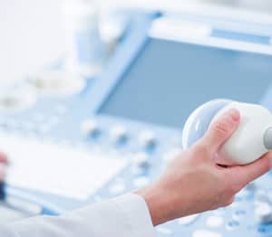 Close up of technician's hands operating a vascular ultrasound